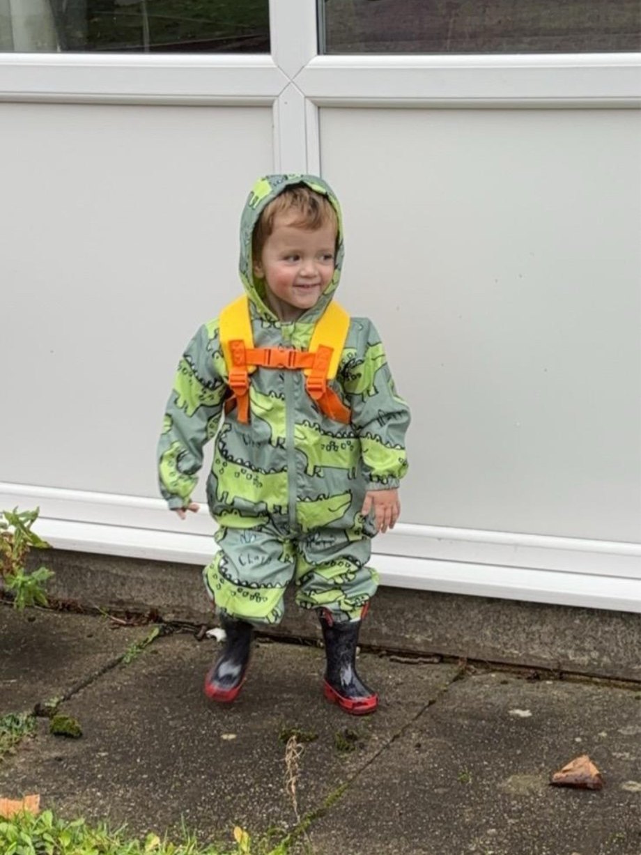 Lync smiling in his crocodile puddle suit and wellies