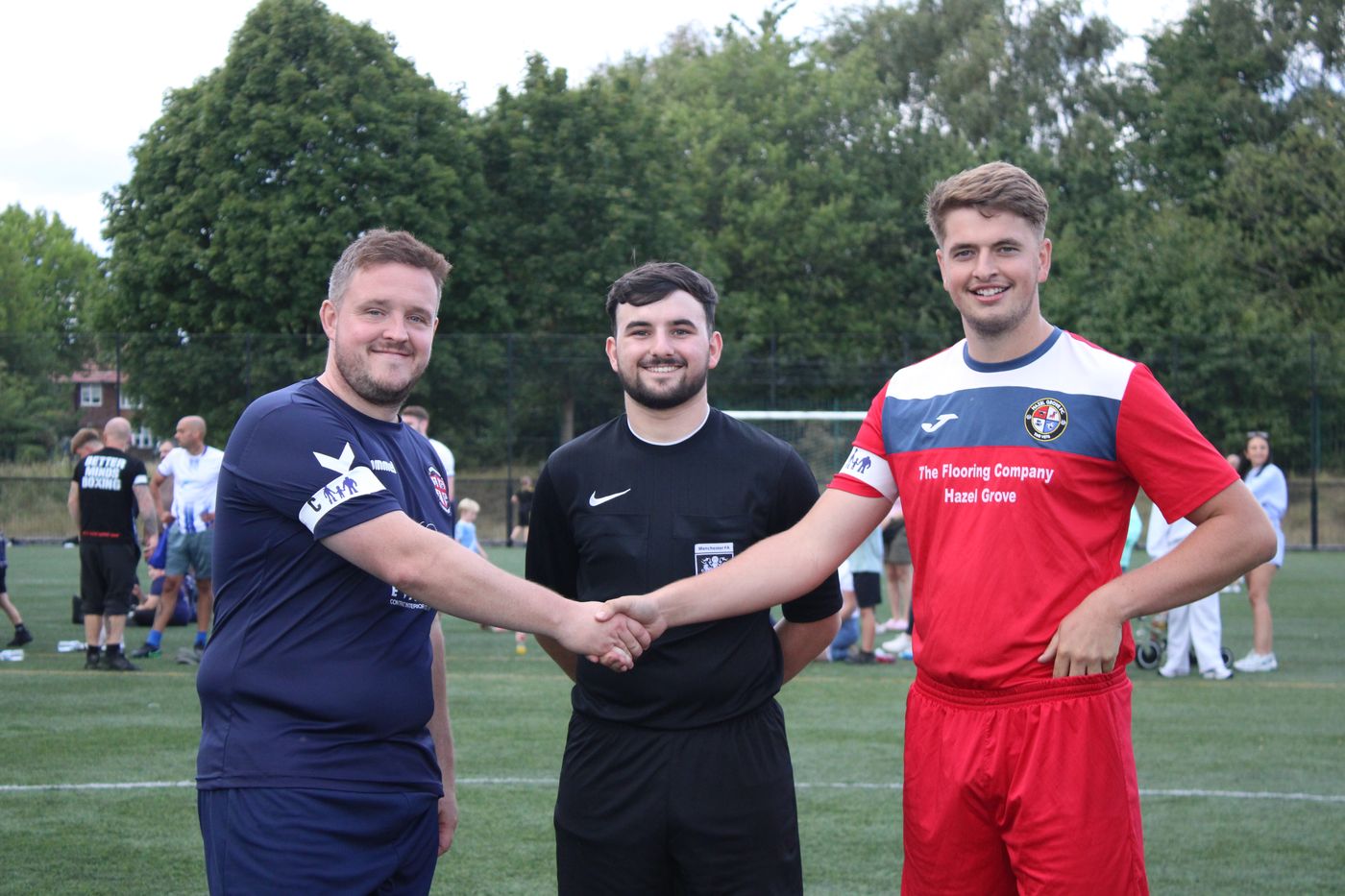 Two captains shaking hands with the referee before a match