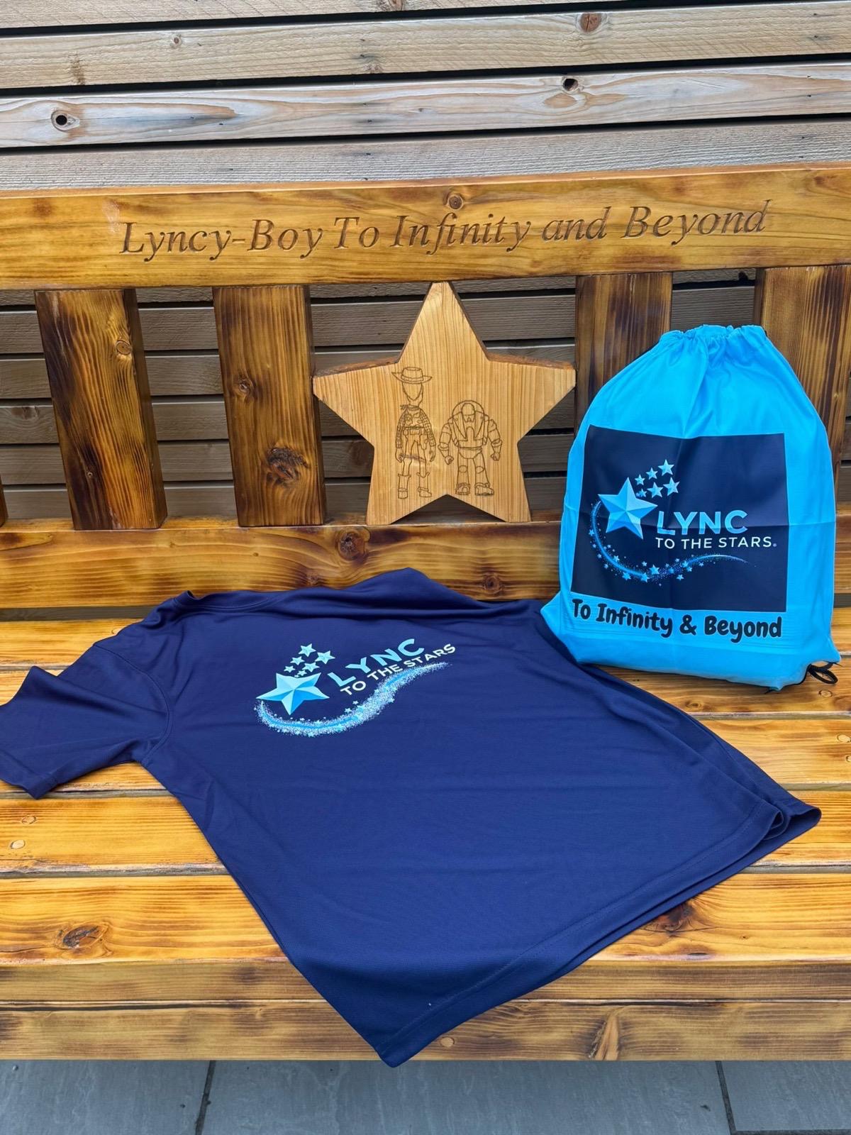 Lync's Bench with a Lync to the Stars t-shirt, drawstring bag and carved wooden star laid on it