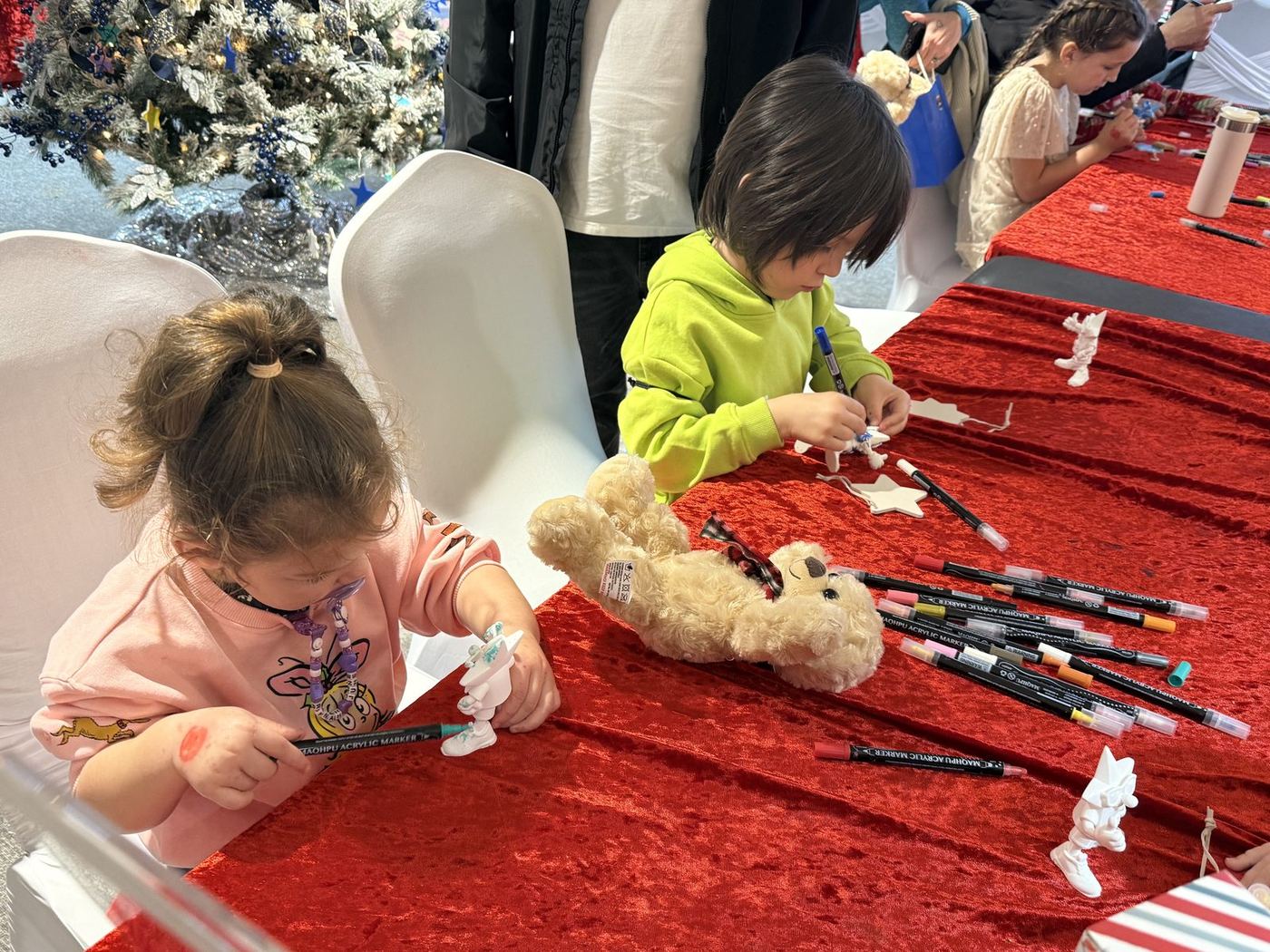A little girl decorating her craft at the table