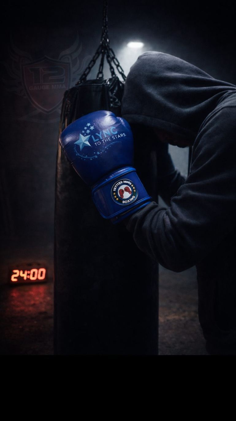 A boxer in a hood at the punch bag late into the night