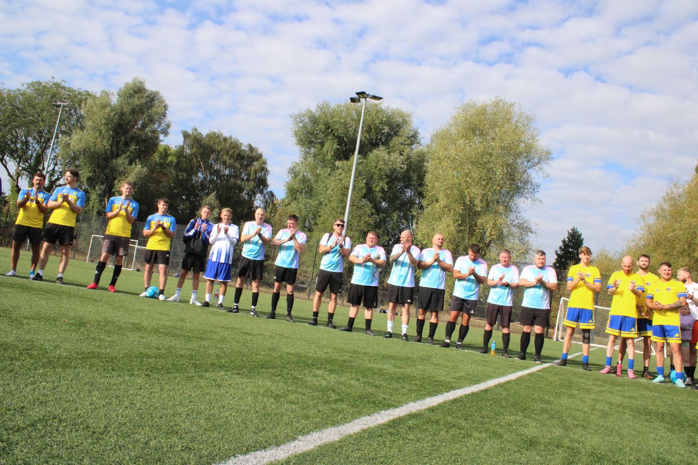 Teams lined up and applauding together at the start of the tournament