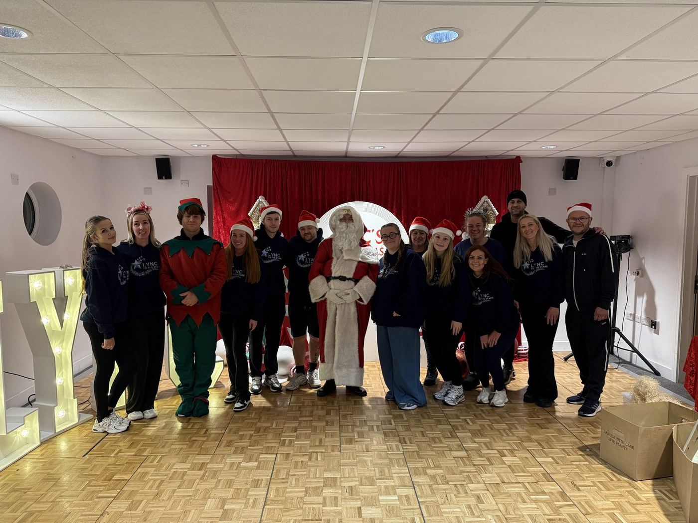 The whole team with Santa and his elves