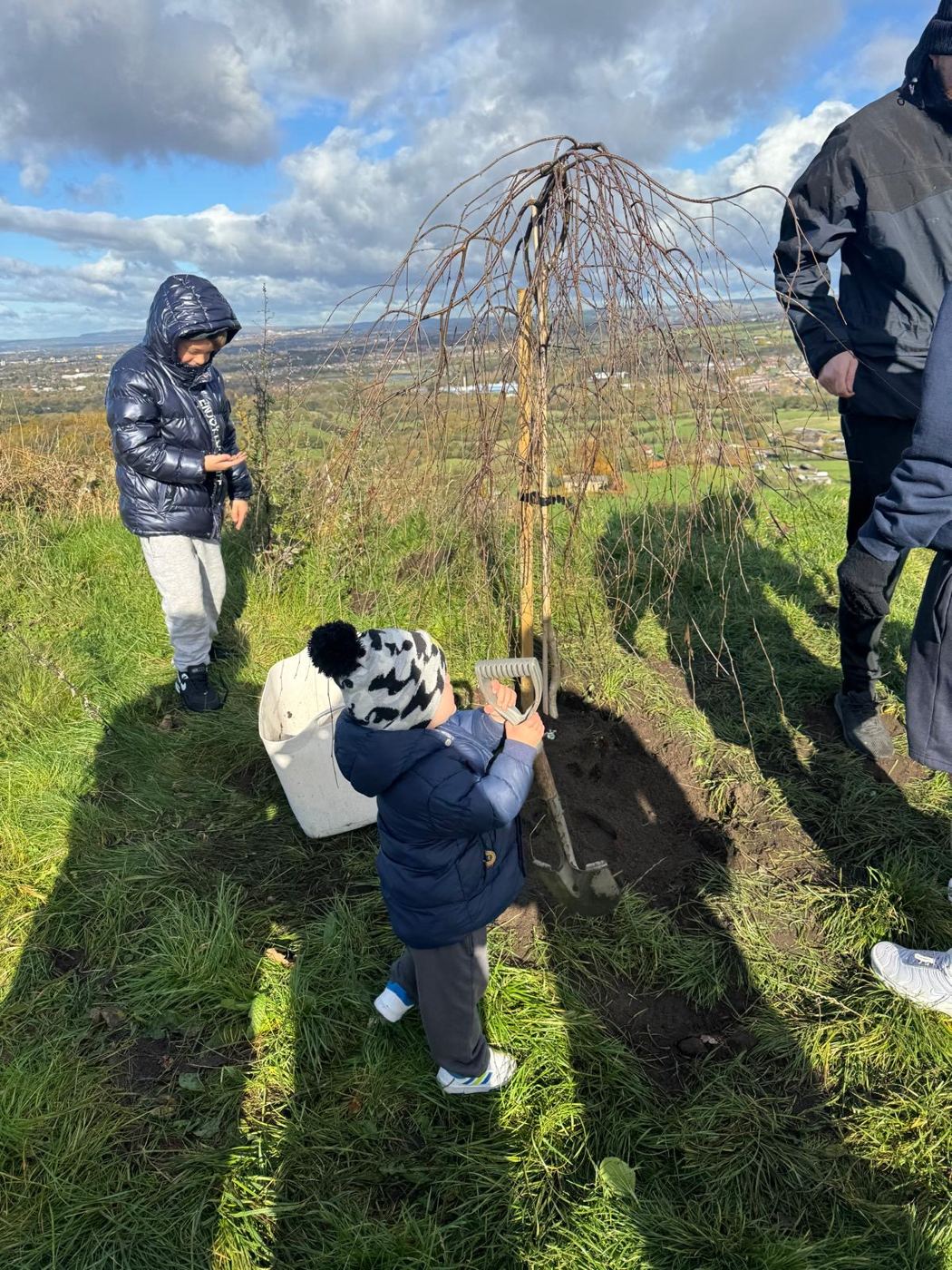 A little one helping to plant Lync's Tree