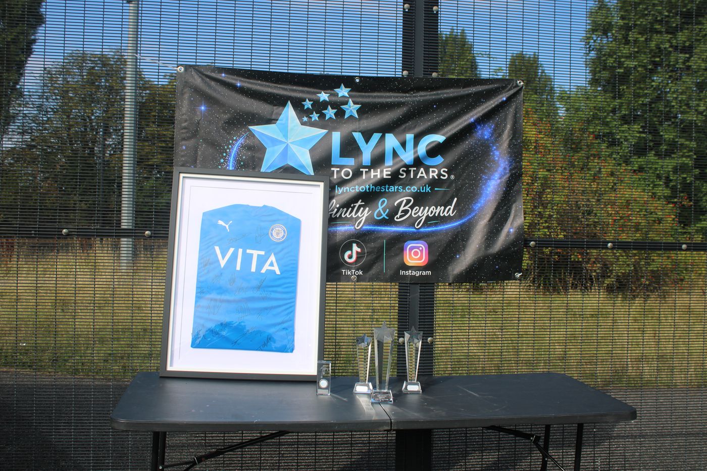The Lync to the Stars banner with a framed shirt and the trophies