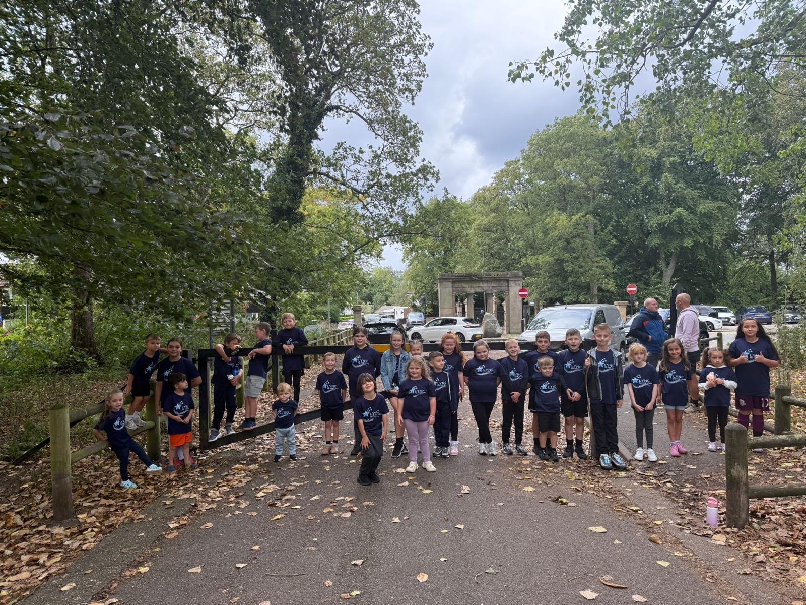 A big group of children in Lync to the Stars t-shirts gathered on the park path