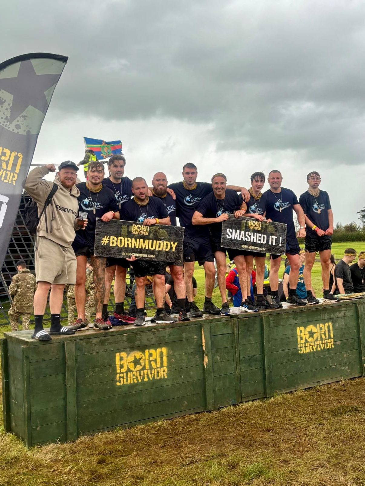 The Born Survivor team on the finish podium with their Born Muddy and Smashed It signs