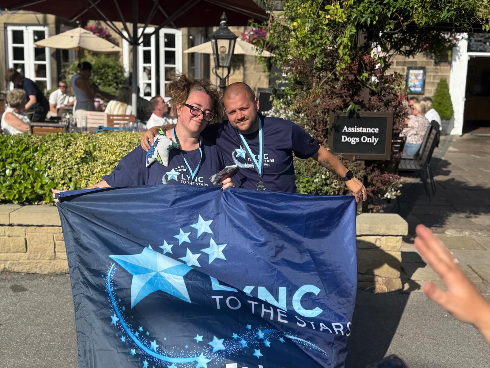 Two supporters holding the banner outside the venue before the walk