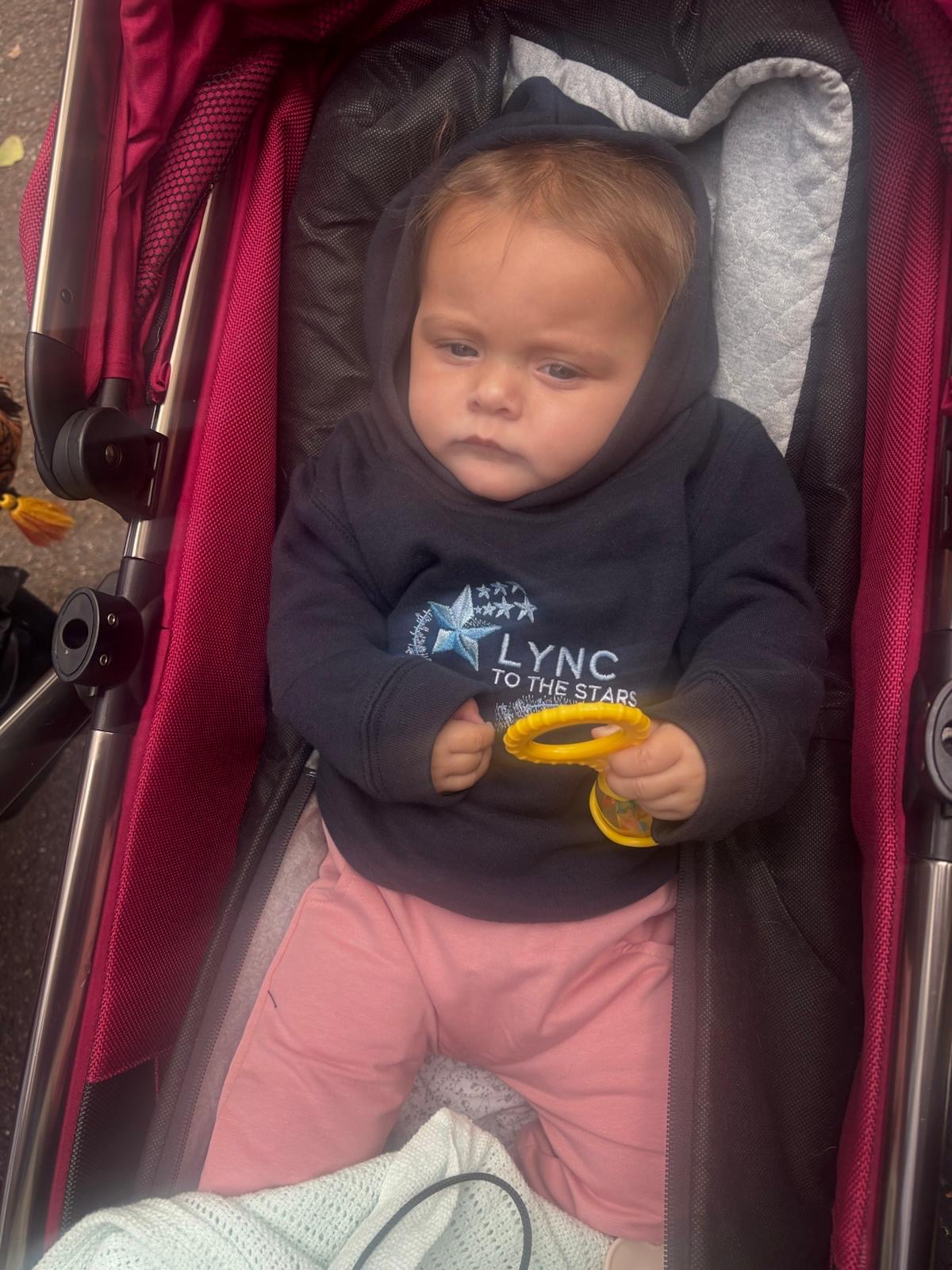 A little one in a Lync hoodie joining in from the pushchair
